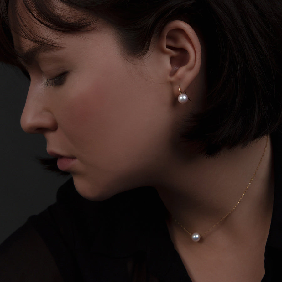 Modell trägt Ohrhaken aus 750 Gold mit Akoya-Perle und passende Kette